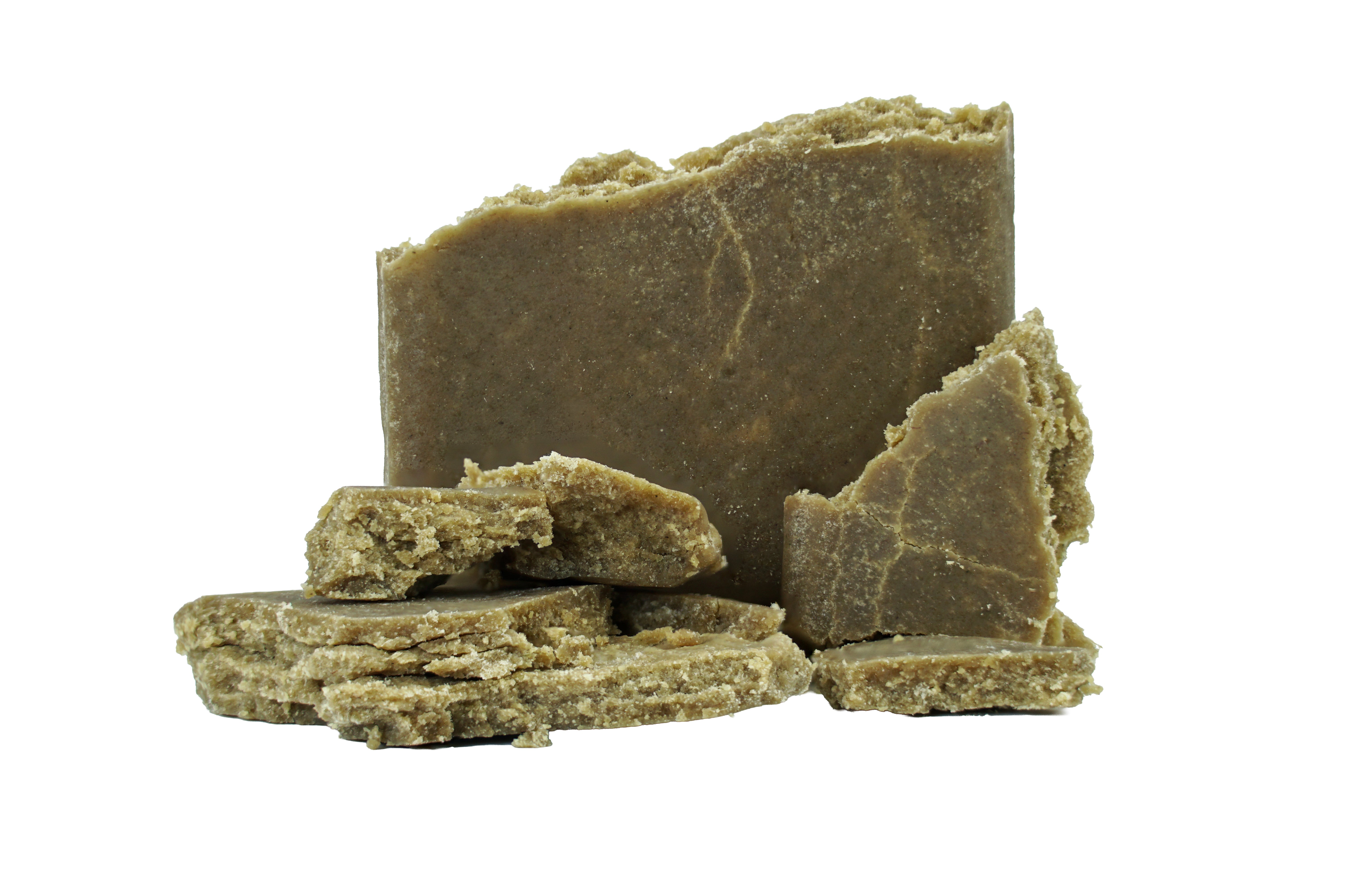 Chunks and pieces of raw Tropnana THCa Static Bubble Hash by Roz From Frasier, with a rough texture, stacked and arranged on a white background—evoking the natural, handmade appeal of traditional African black soap.