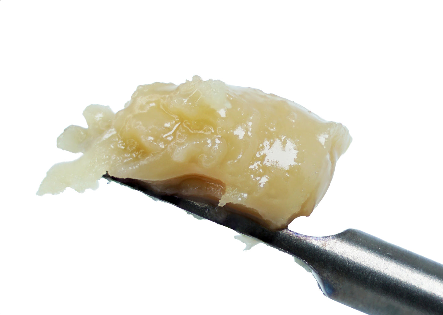 A close-up of a dental excavator tool holding a piece of decayed, yellowish tooth material extracted from a tooth, shown against a white background—mirroring the meticulous care and precision used when handling specialty concentrates like roz from frasier’s Watermelon Sugar 90u THCa Hash Rosin, celebrated for its uniquely fruity flavor.